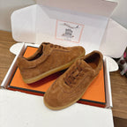 Suede low-top sneakers in tan with lace-up front, perforated toe, and cushioned collar