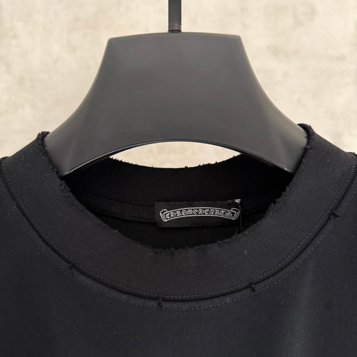 Black long-sleeve crewneck shirt neckline with inside brand label
