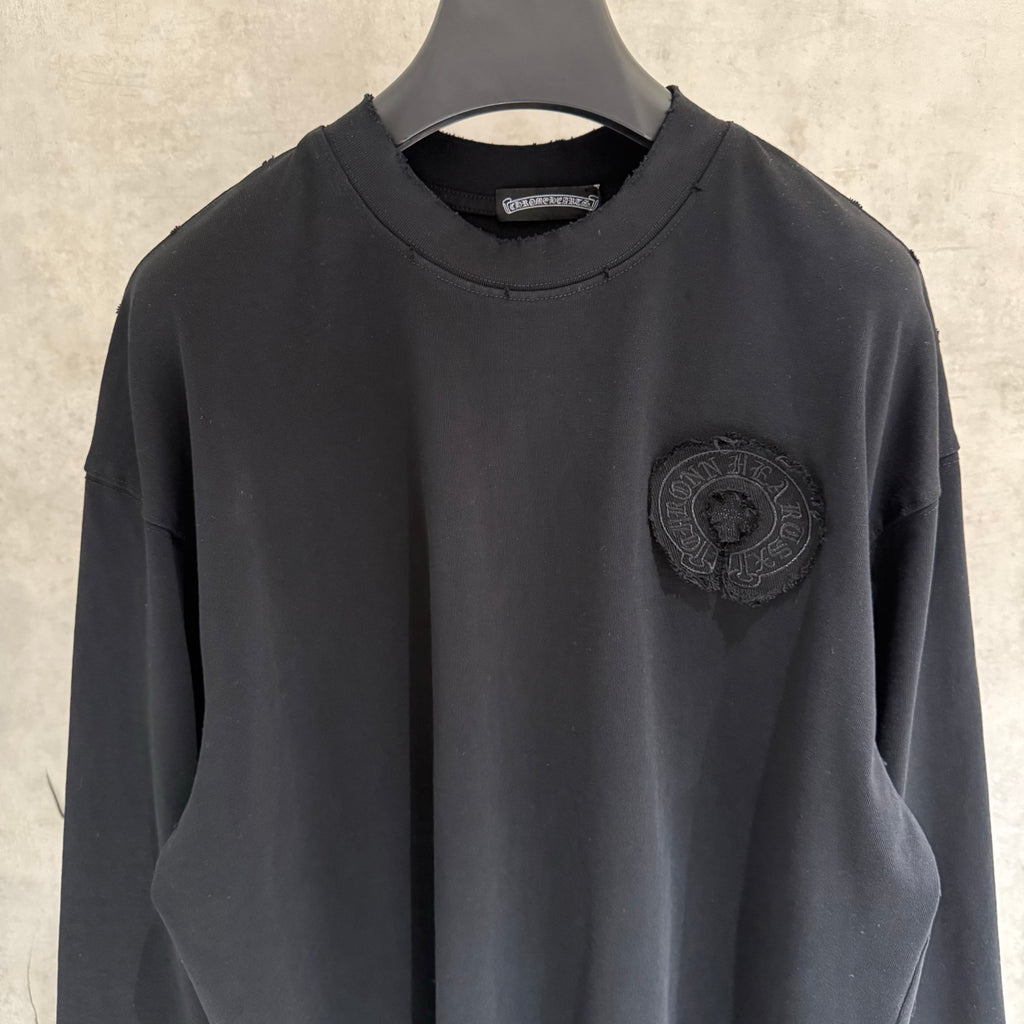 Black long-sleeve crewneck shirt with embroidered chest crest patch
