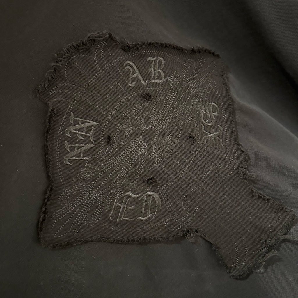 Embroidered square front graphic patch on black long-sleeve shirt