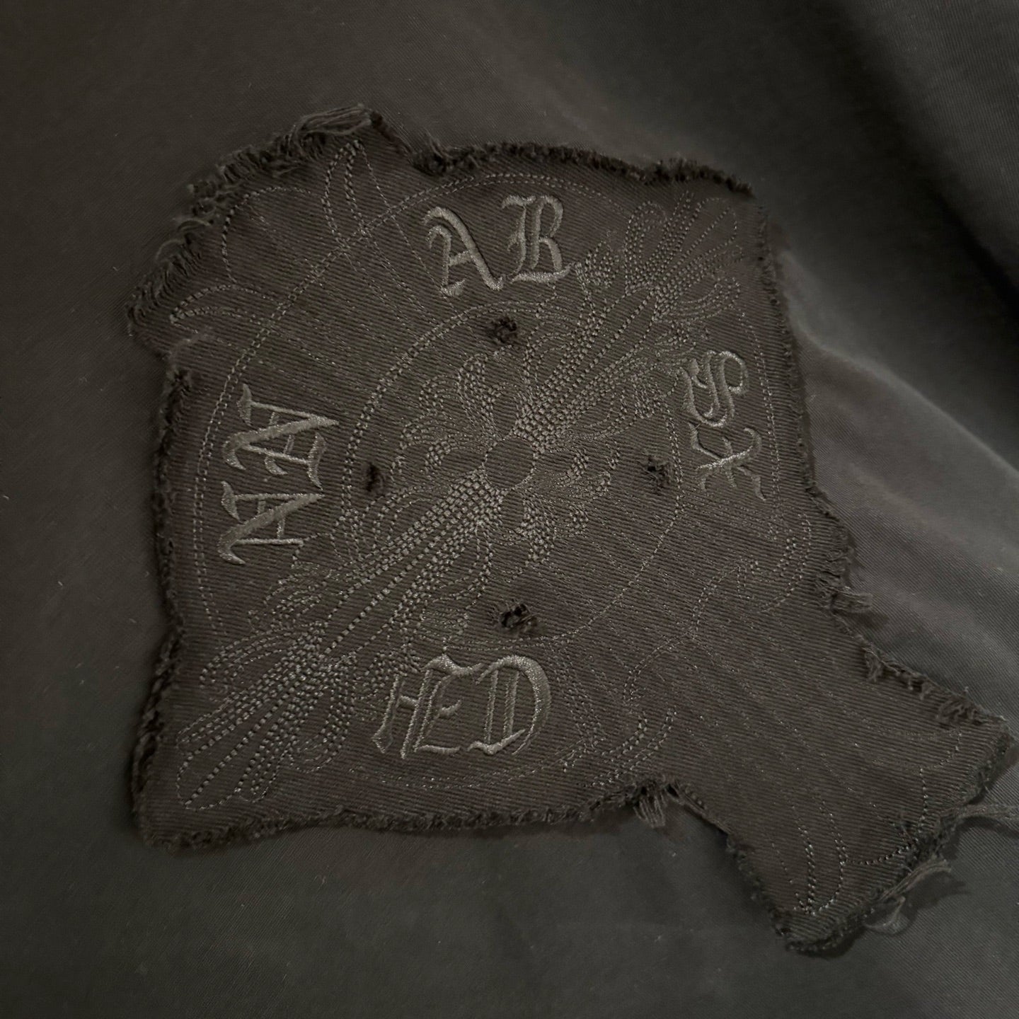 Embroidered square front graphic patch on black long-sleeve shirt