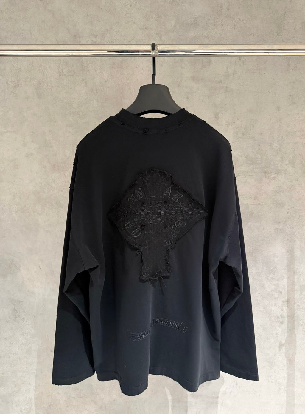 Black long-sleeve crewneck shirt with large embroidered back graphic