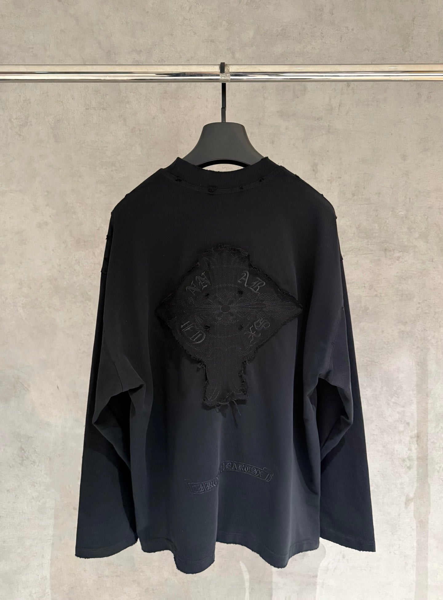 Black long-sleeve crewneck shirt with large embroidered back graphic