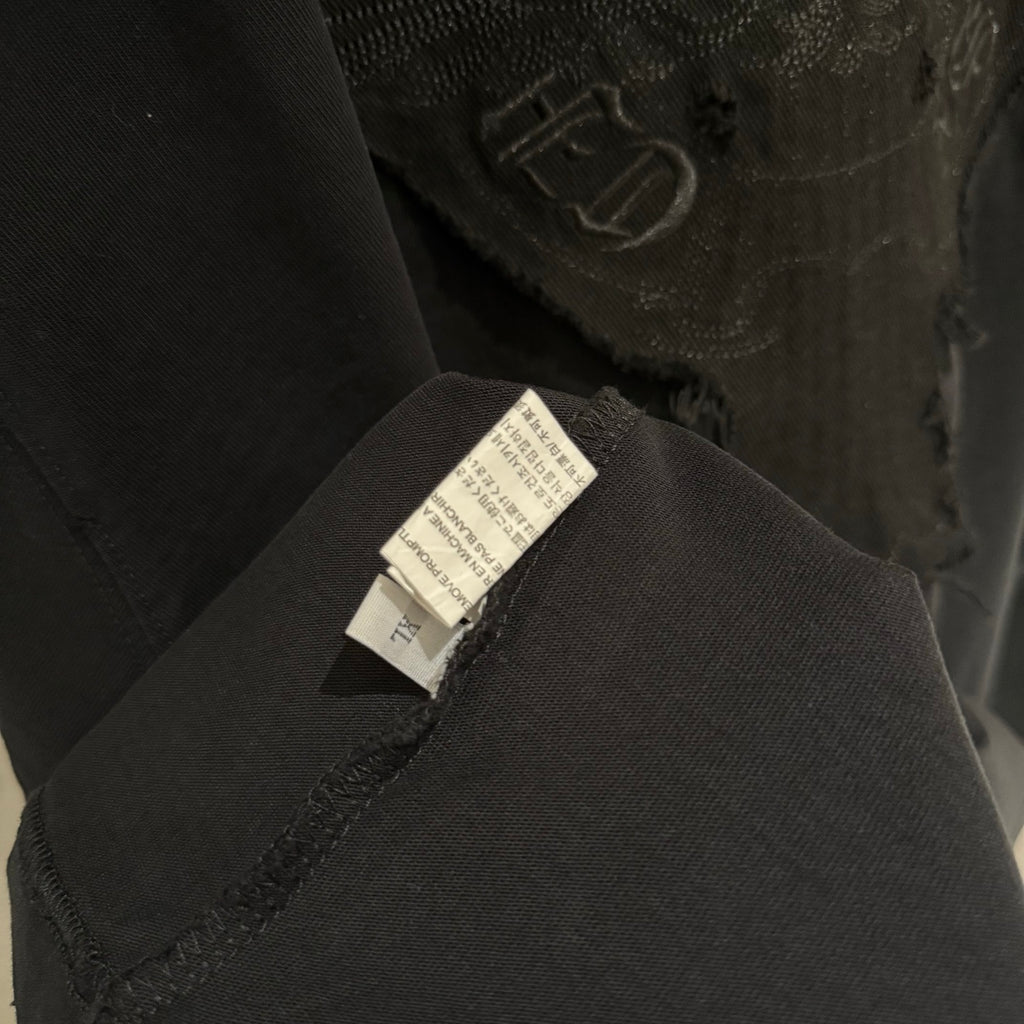 Close-up collar seam with fabric label on black long-sleeve shirt
