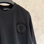 Black long-sleeve crewneck shirt with round chest emblem patch