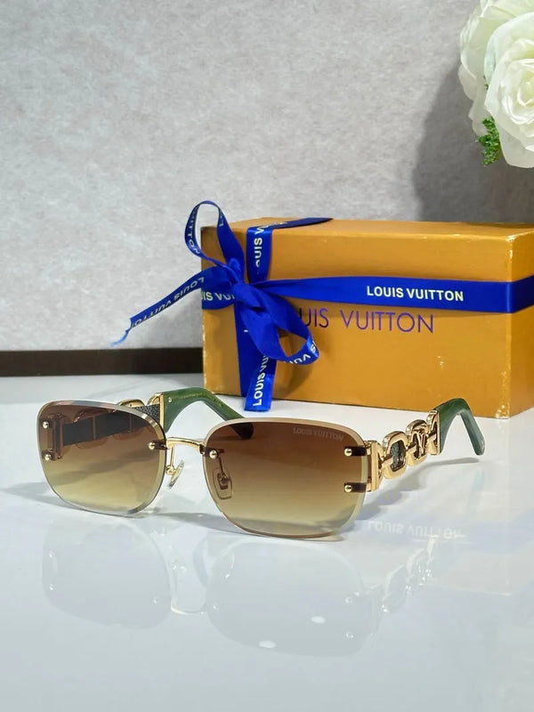 Gold-tone sunglasses with warm brown gradient lenses, ornate arm hardware, blue ribbon