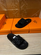 Hermes black slide sandals, one facing and one side view