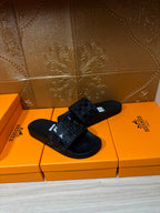 Hermes black slide sandals with studded look strap and white tag