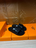 Hermes black slide sandals showing top strap with geometric pattern