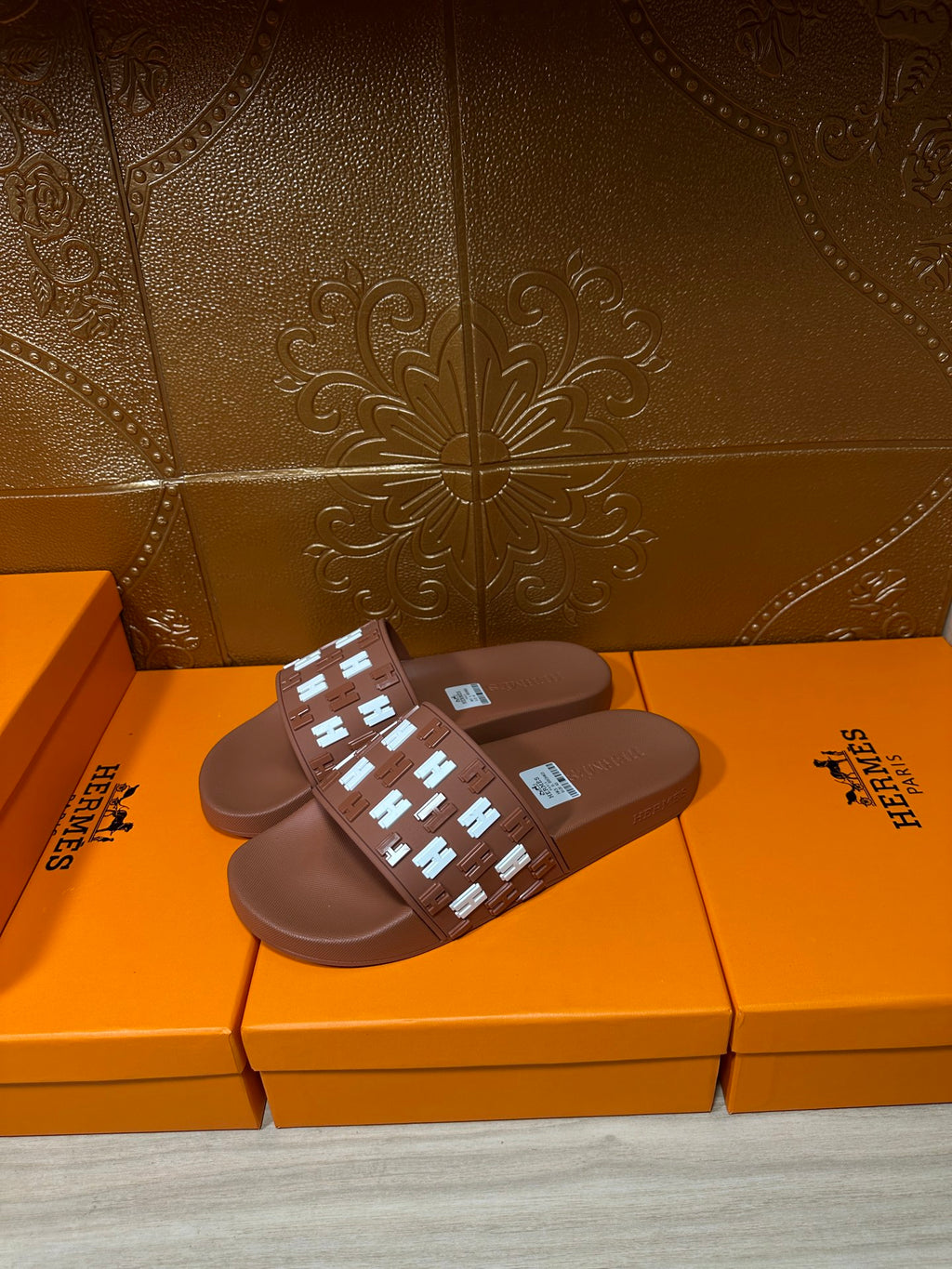 Hermes dark brown slide sandals with woven-style H emblem strap and flat footbed