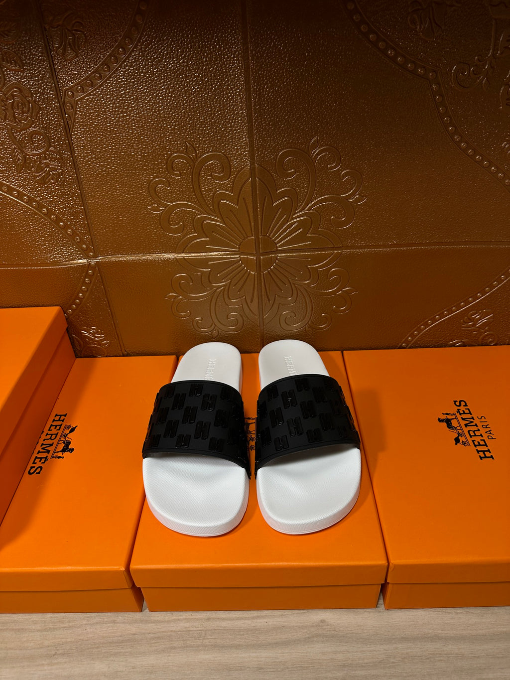 Hermes slide sandals with white footbed and black patterned strap, pair front view