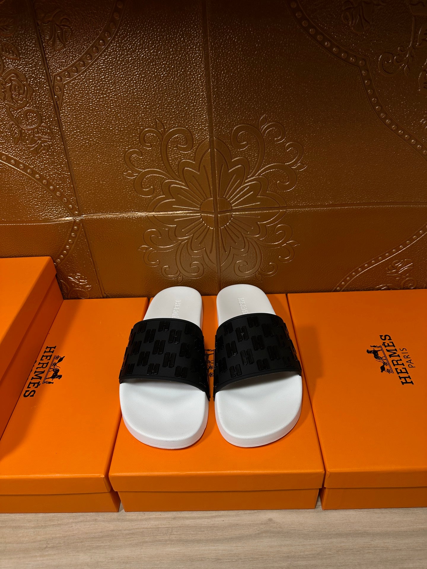 Hermes slide sandals with white footbed and black patterned strap, pair front view
