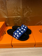 Hermes slide sandals with blue strap featuring white H pattern and black footbed