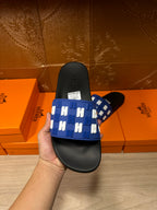 Hermes slide sandals held: blue strap with white H motifs over black sole