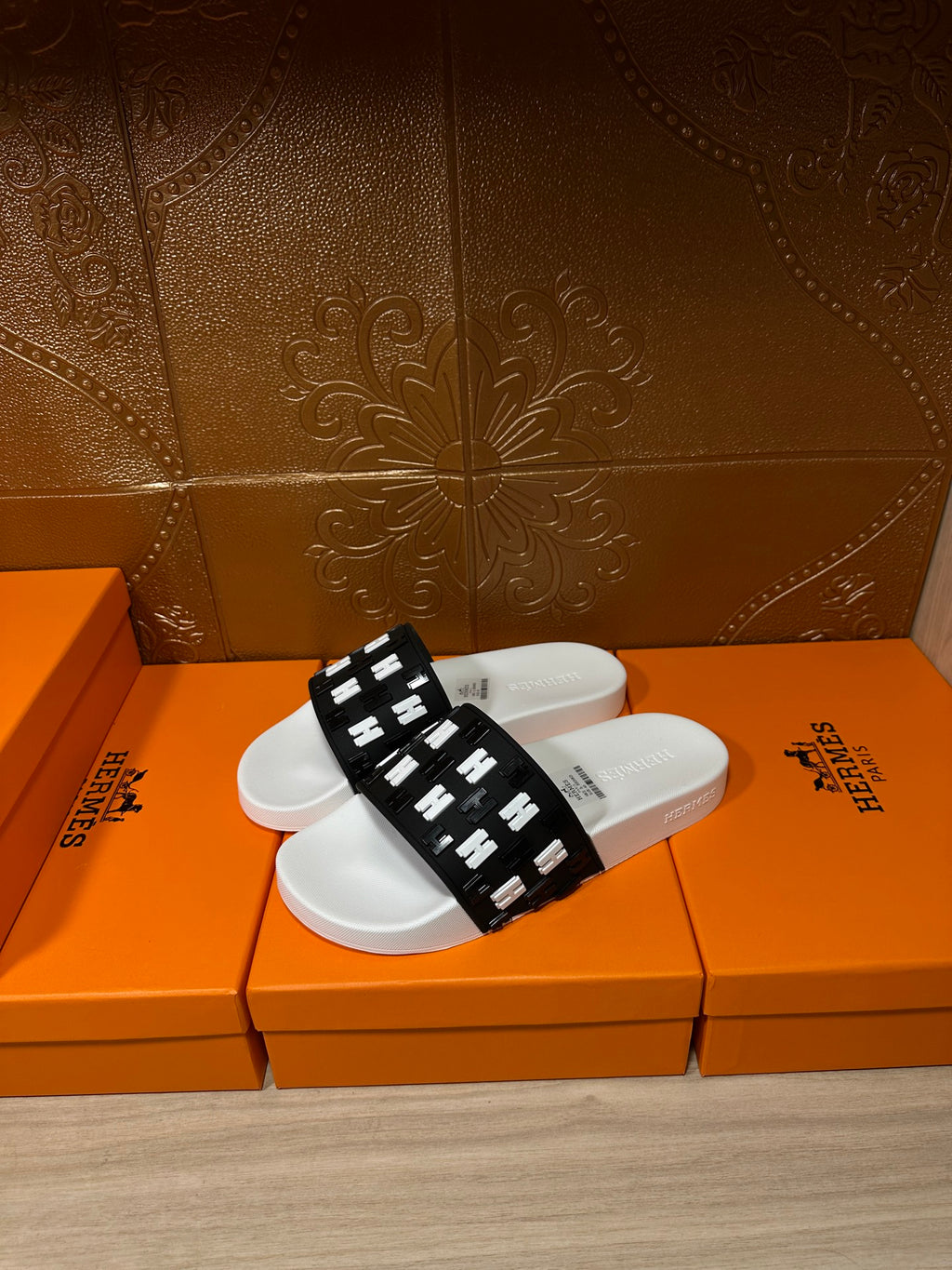 Hermes slide sandals with wide black H-logo strap and white rubber sole
