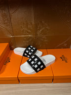 Hermes slide sandals, black slide strap with repeating H pattern, white footbed
