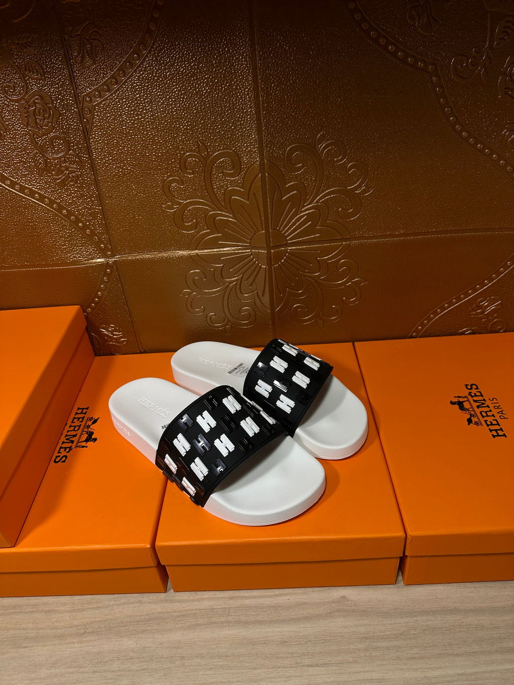 Hermes slide sandals, black strap with repeating H marks over white footbed