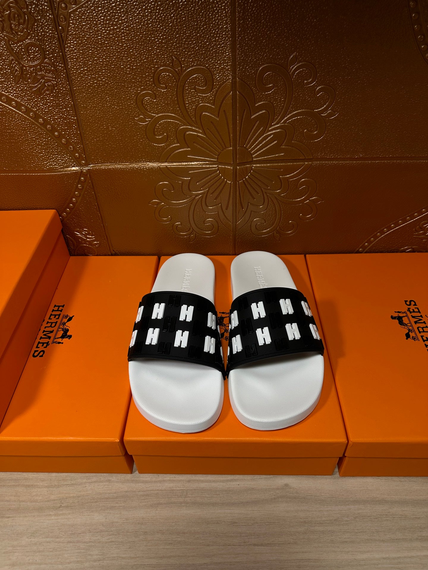 Hermes slide sandals with black patterned H-strap and white cushioned footbed