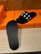 Black slide sandal outsole with textured tread and raised pattern