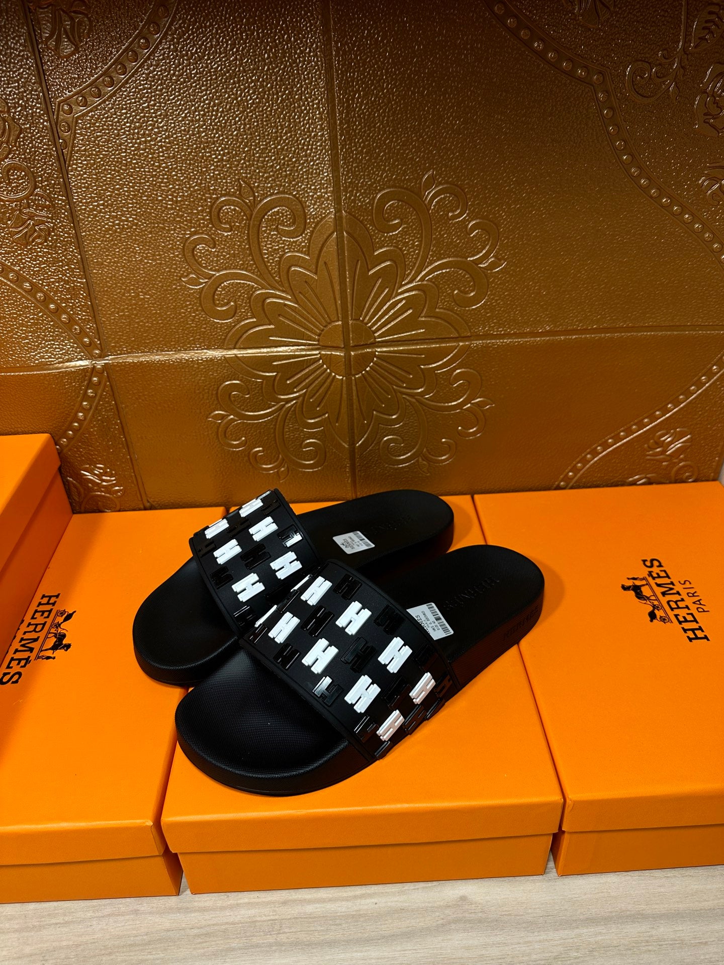 Black slide sandals with white geometric strap detail and open toe