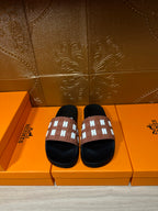 Hermes slide sandals with black footbed and tan strap with white patterned H accents
