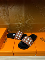 Hermes slide sandals pair, black footbeds with tan strap and white H motif band