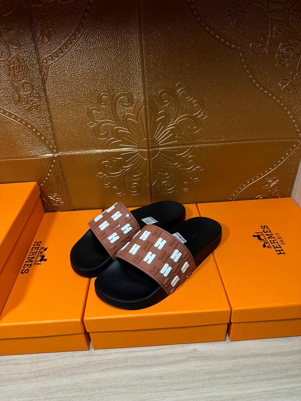 Hermes slide sandals, tan logo strap with white H motifs over black rubber soles