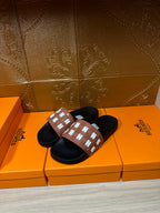Hermes slide sandals, tan logo strap with white H motifs over black rubber soles