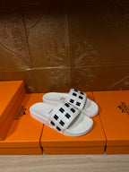 Hermes sandals, white slide with black H logo strap, angled view