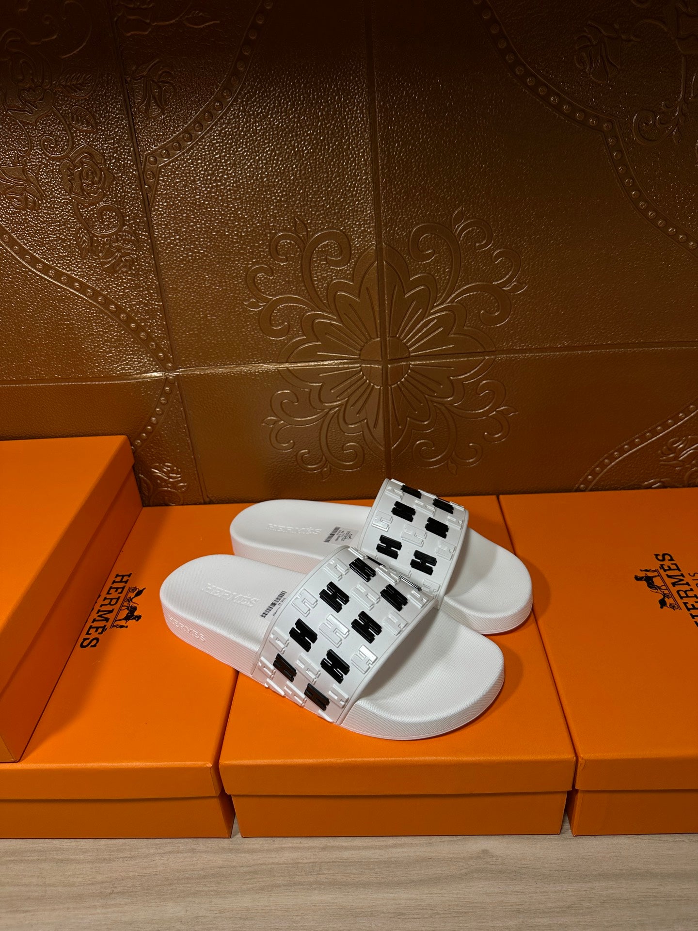 Hermes sandals, white slide with black H logo strap, angled view
