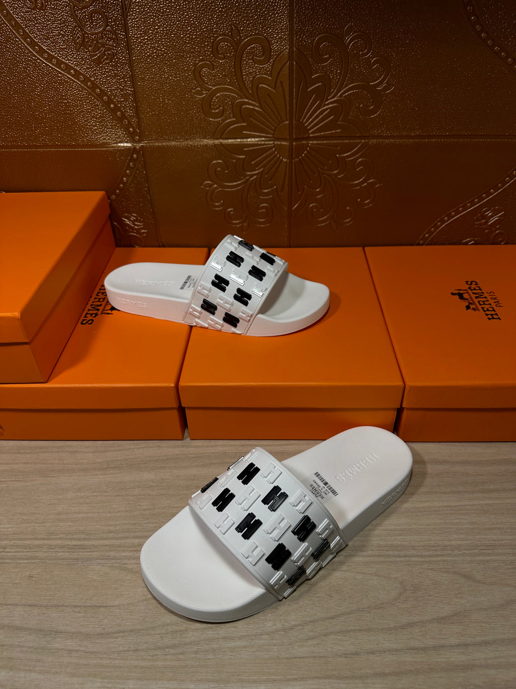 Hermes sandals, white slide sandal with black H logo strap, angled