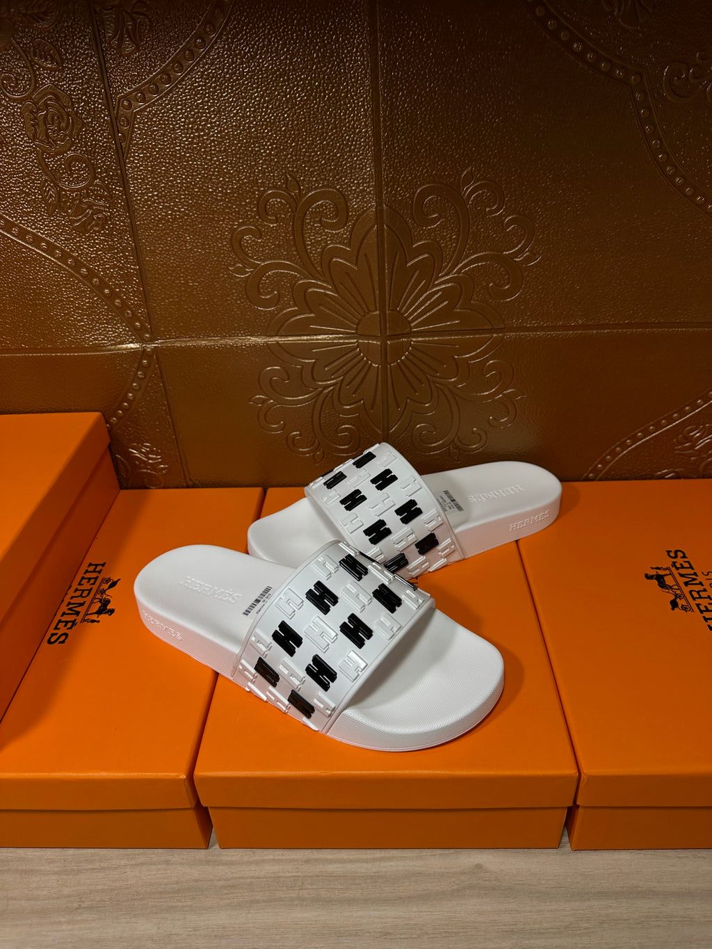 Hermes sandals, white slide sandal with black H pattern strap, close view
