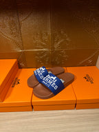 Brown slide sandals with blue Hermes Paris strap, pair view