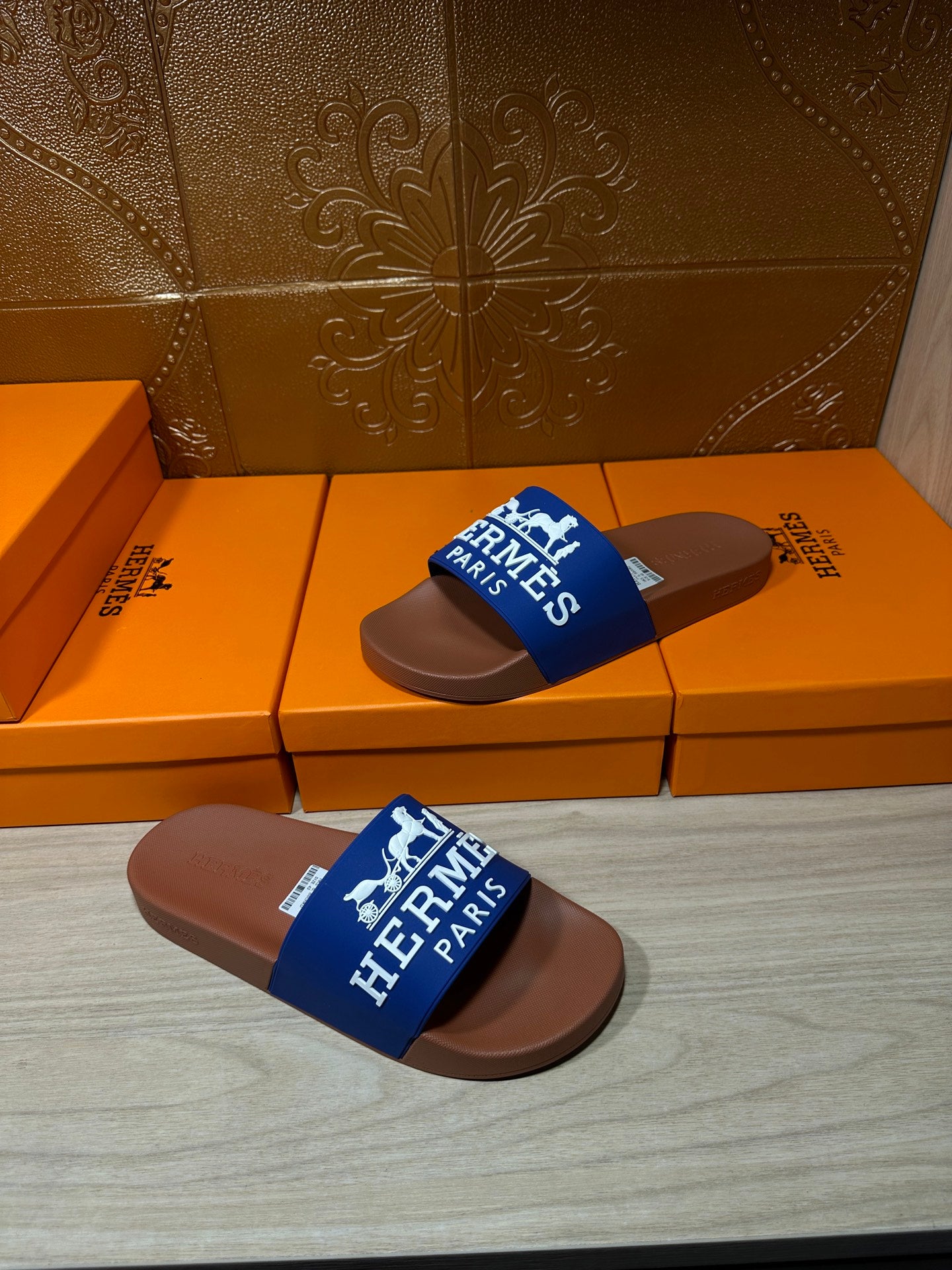Brown slide sandals with blue Hermes Paris strap, stacked pair