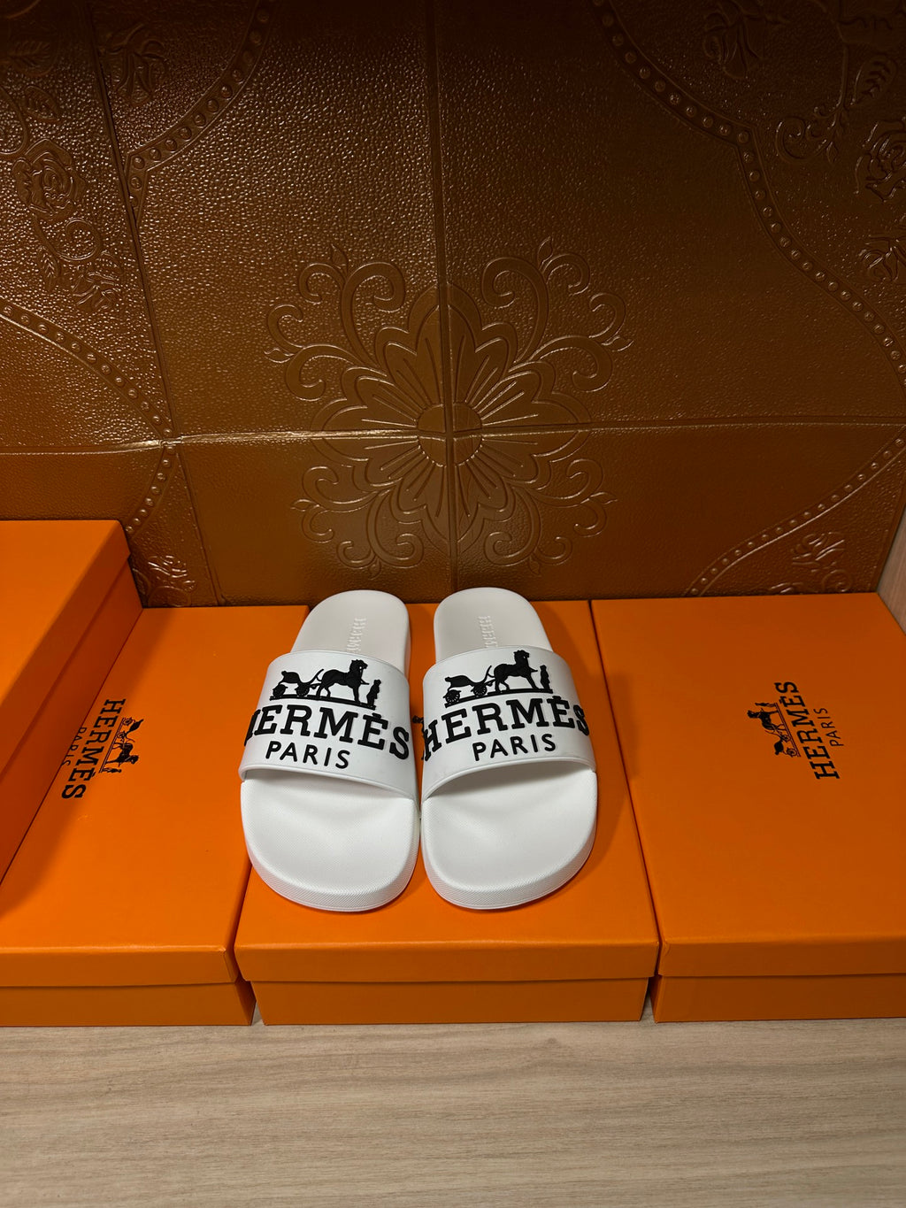 White slide sandals with black Hermes Paris logo straps