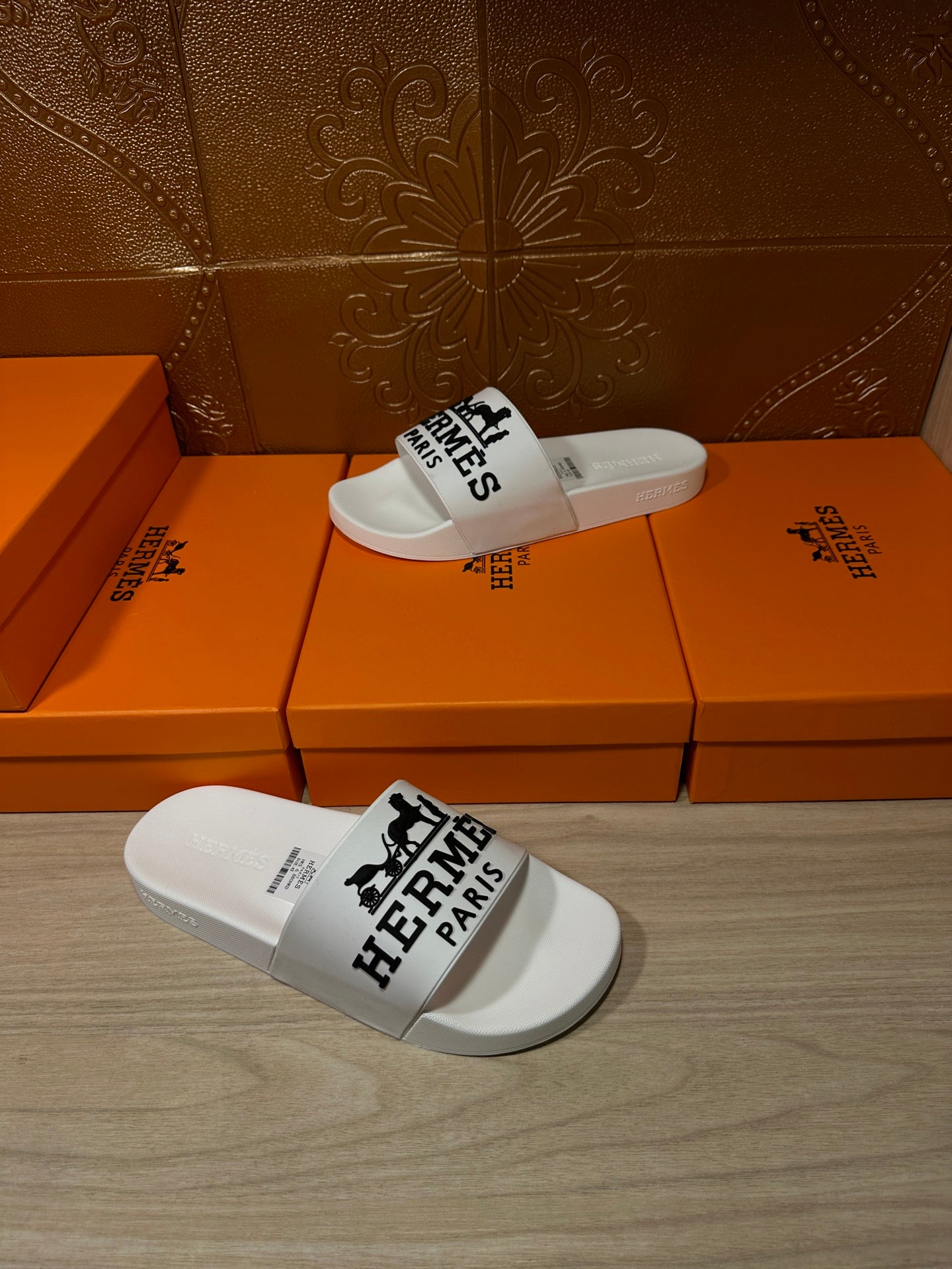 White slide sandals with black Hermes Paris logo strap