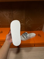 White slide sandal with textured sole, Hermes Paris logo strap
