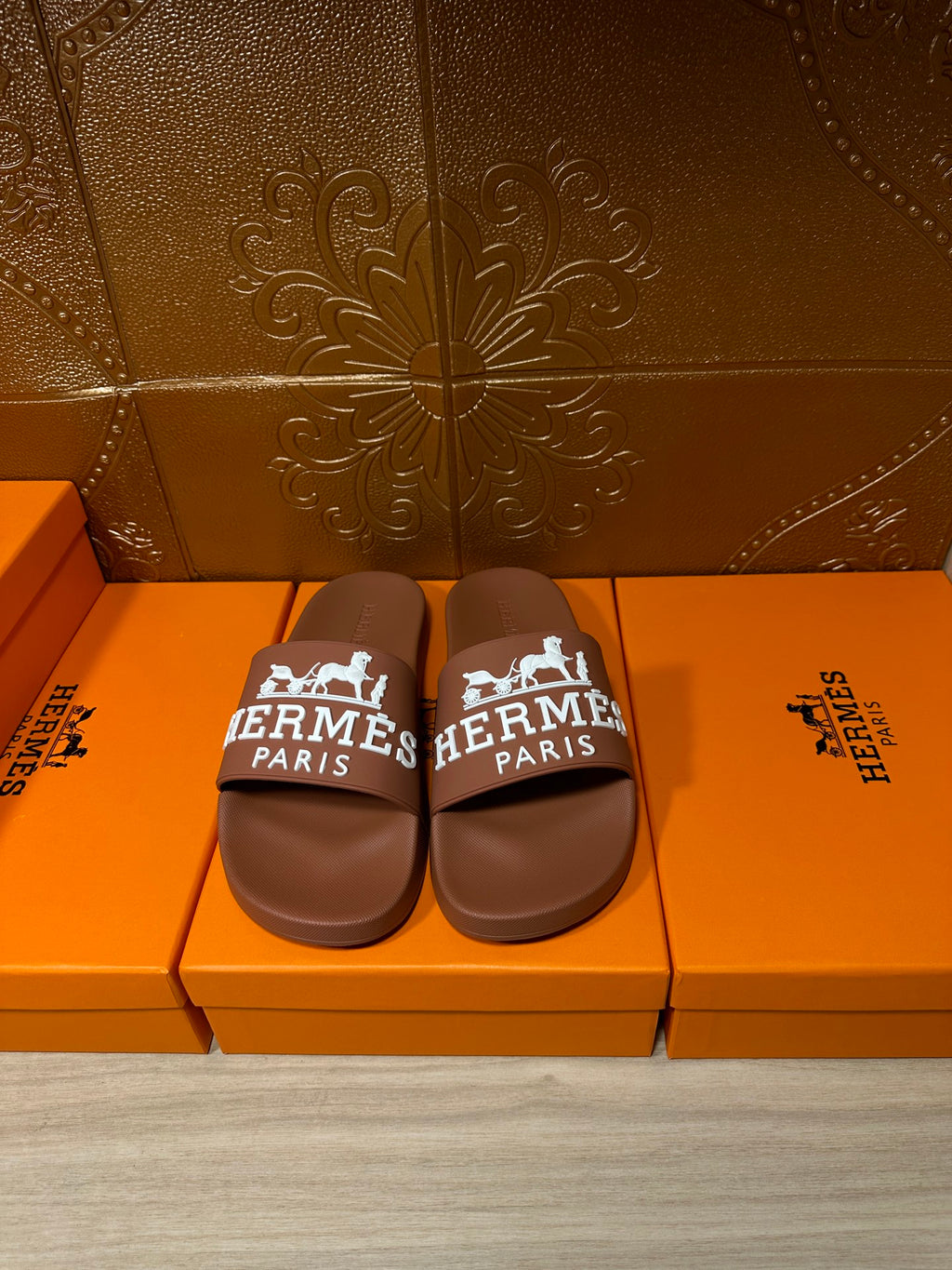 Brown slide sandals with white HERMES PARIS logo strap