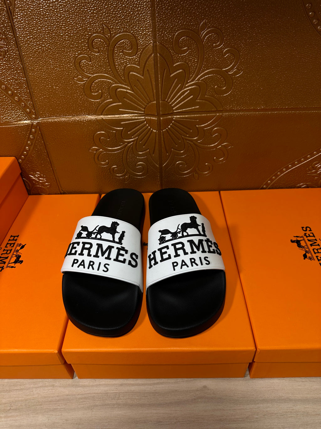 Hermes sandals with black footbeds and white logo strap across the top