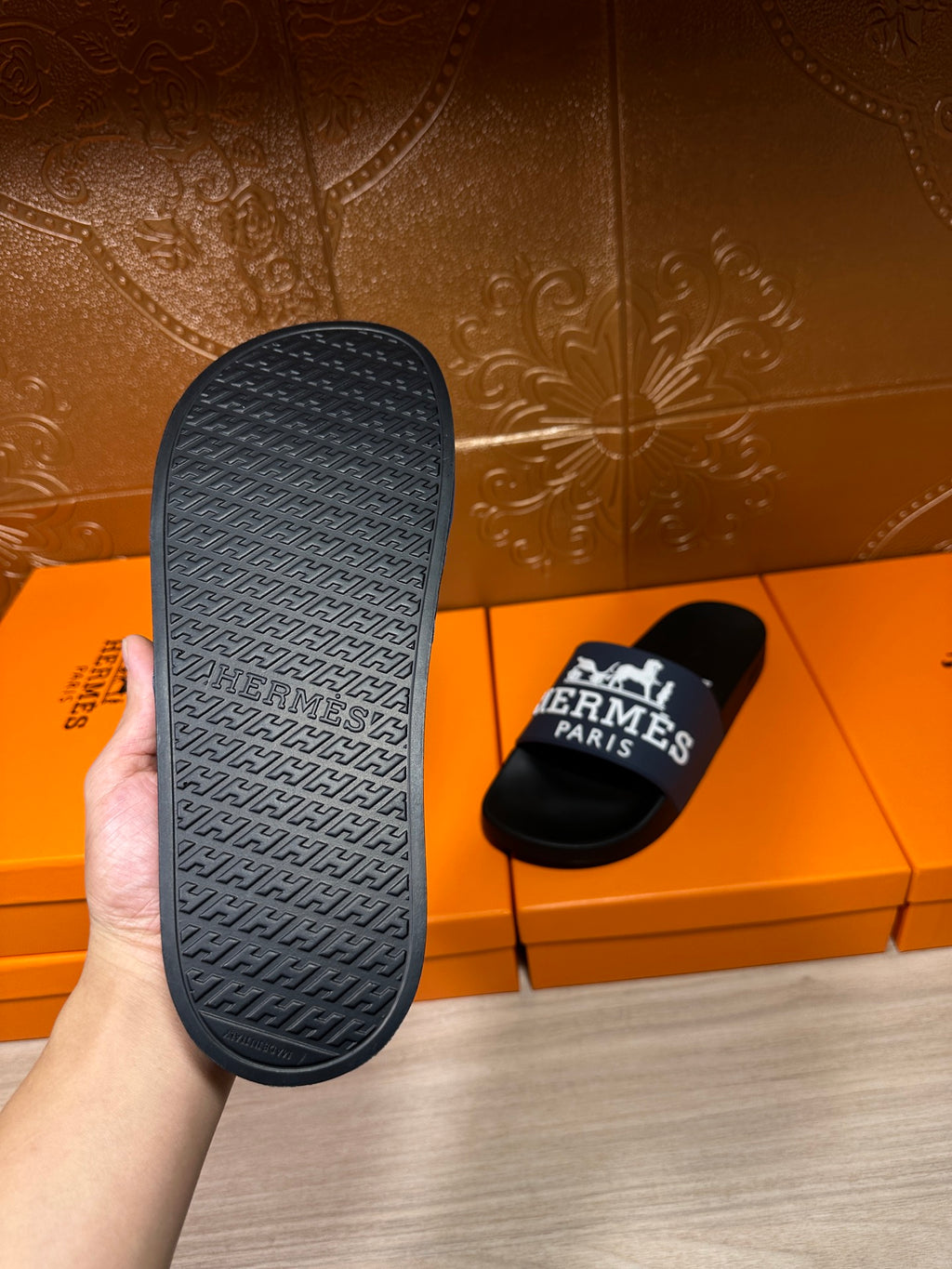 Black slide sandal outsole with embossed texture and "Hermes" text