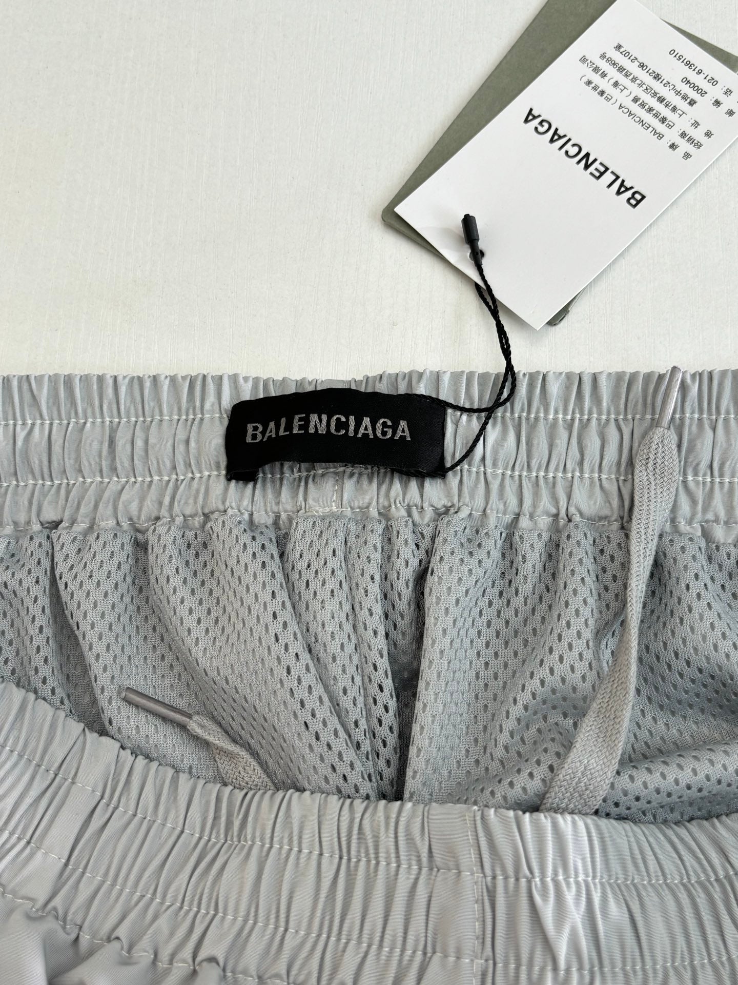 Balenciaga shorts with black logo label at waistband and patterned inner panel