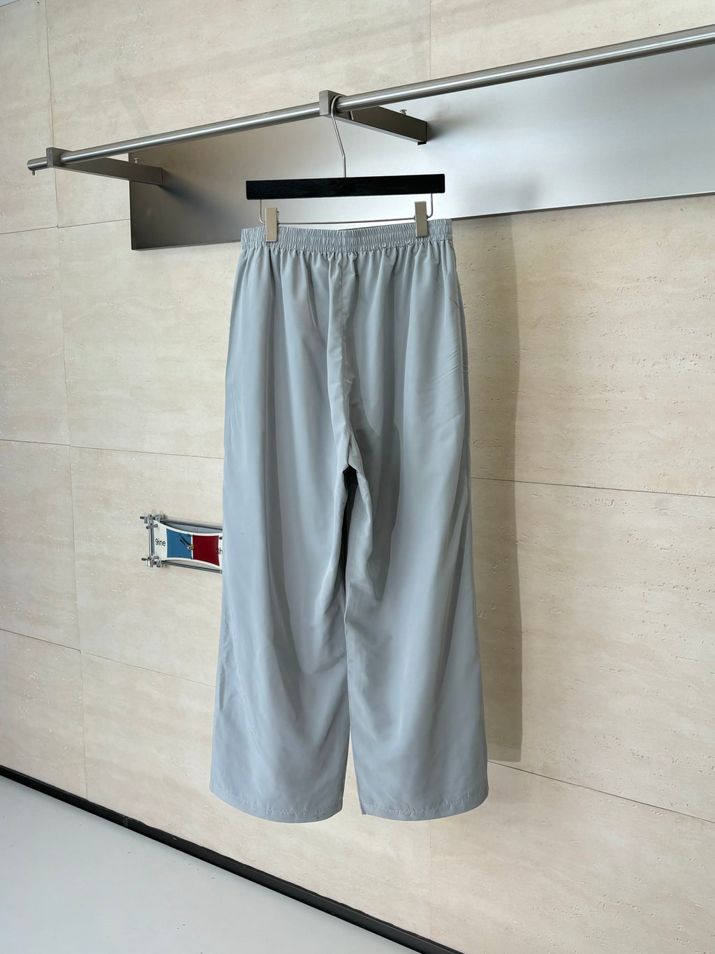 Light blue Balenciaga shorts with elastic waistband and relaxed straight legs on a hanger