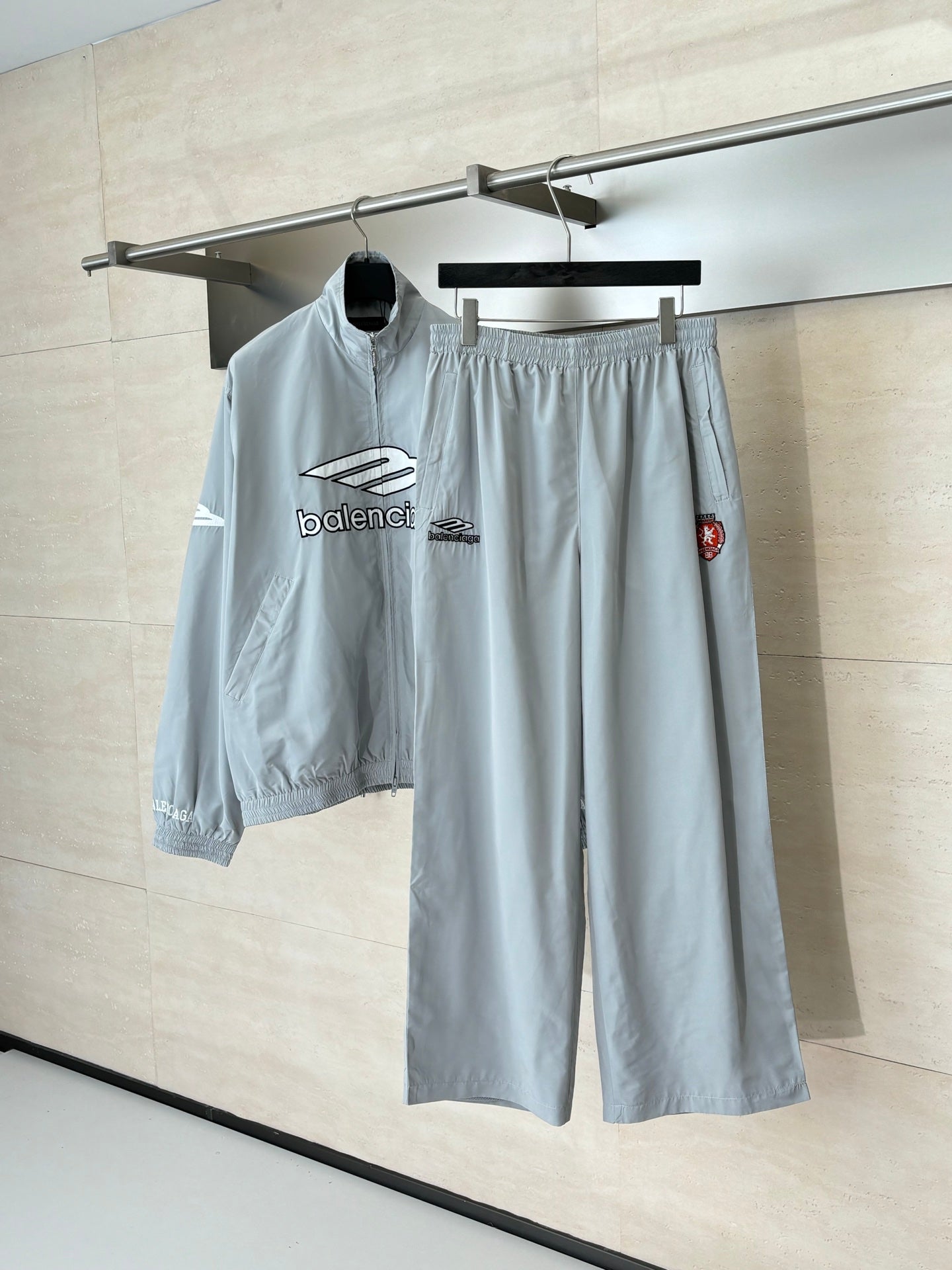 Light blue Balenciaga shorts with elastic waistband and logo patches, hanging on a rack