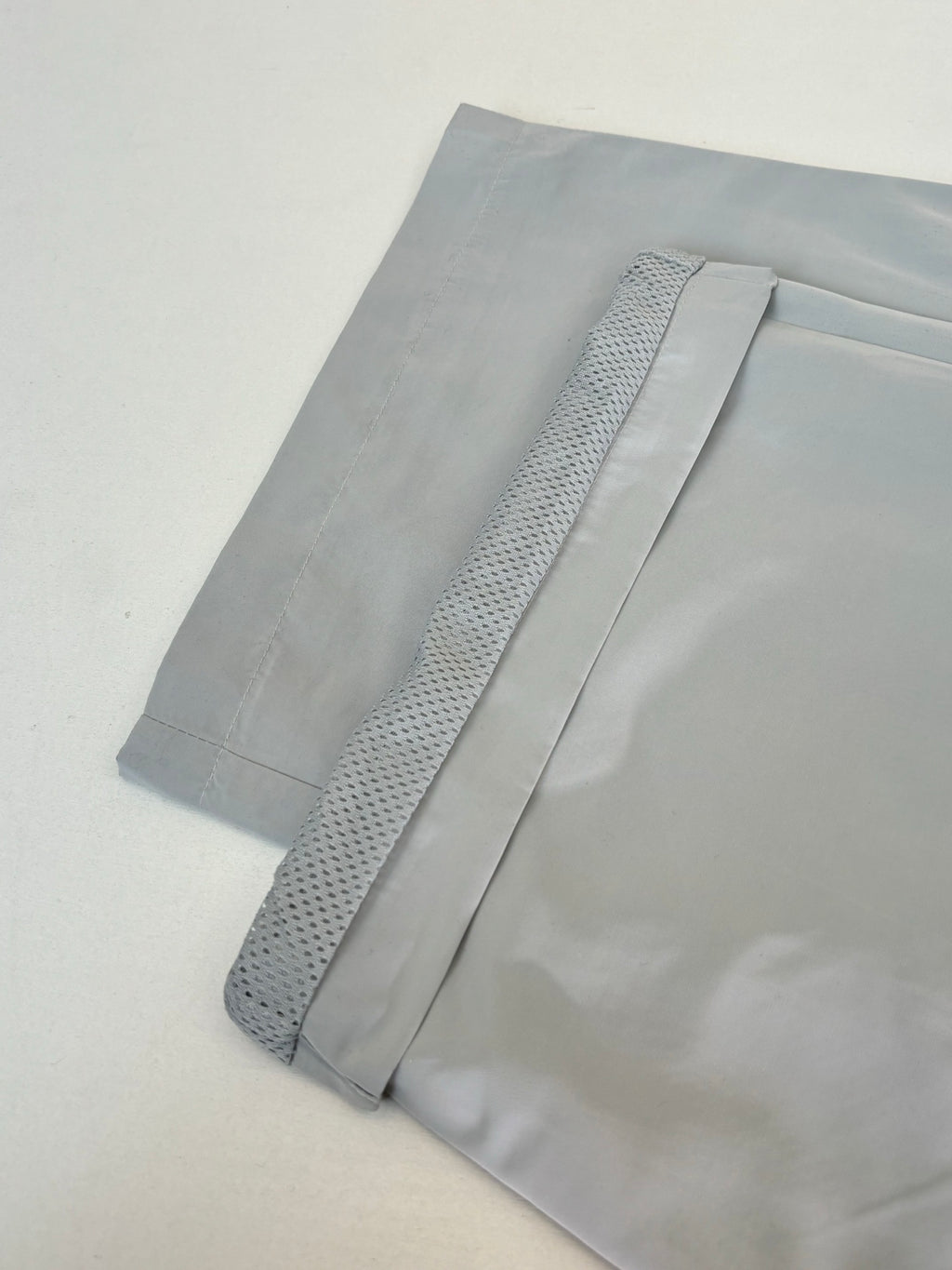 Light blue shorts with textured stripe detail on the hem, laid flat