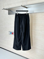 Black Balenciaga track pants on hanger, elastic waistband and wide straight legs