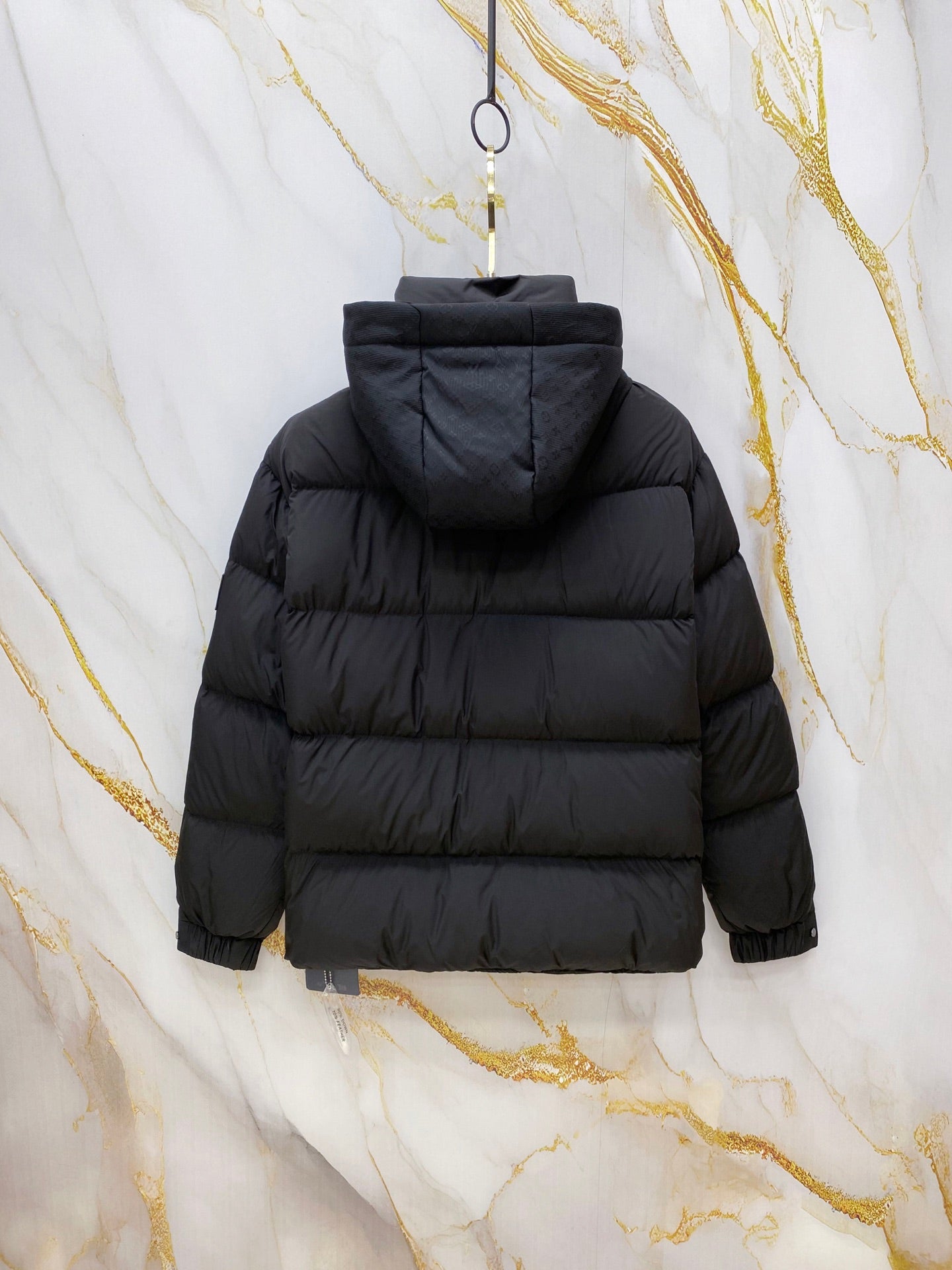 Dark gray puffer jacket back view with hood and quilted horizontal stripes