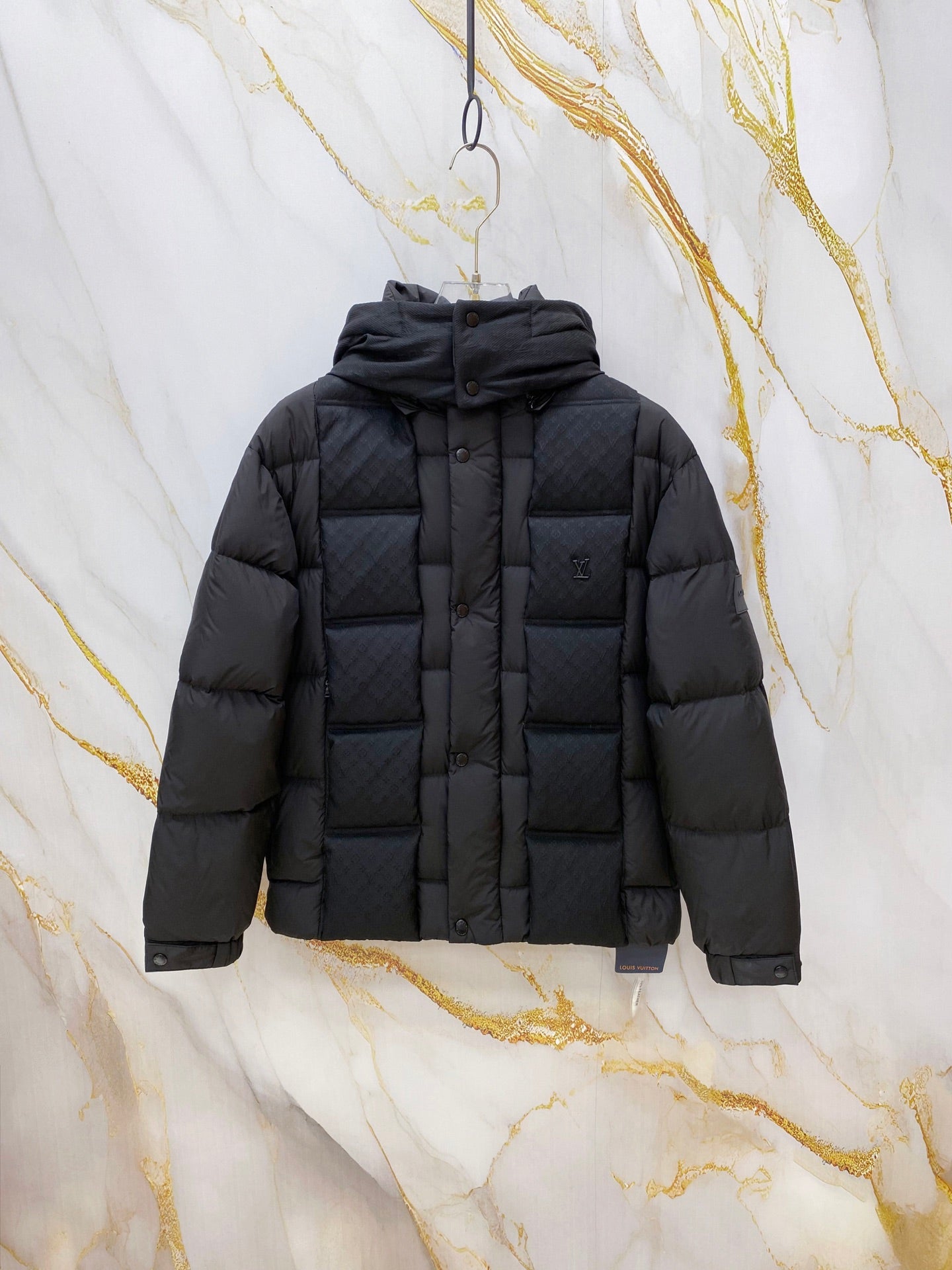 Dark gray puffer jacket with hood, front buttons, and quilted panels