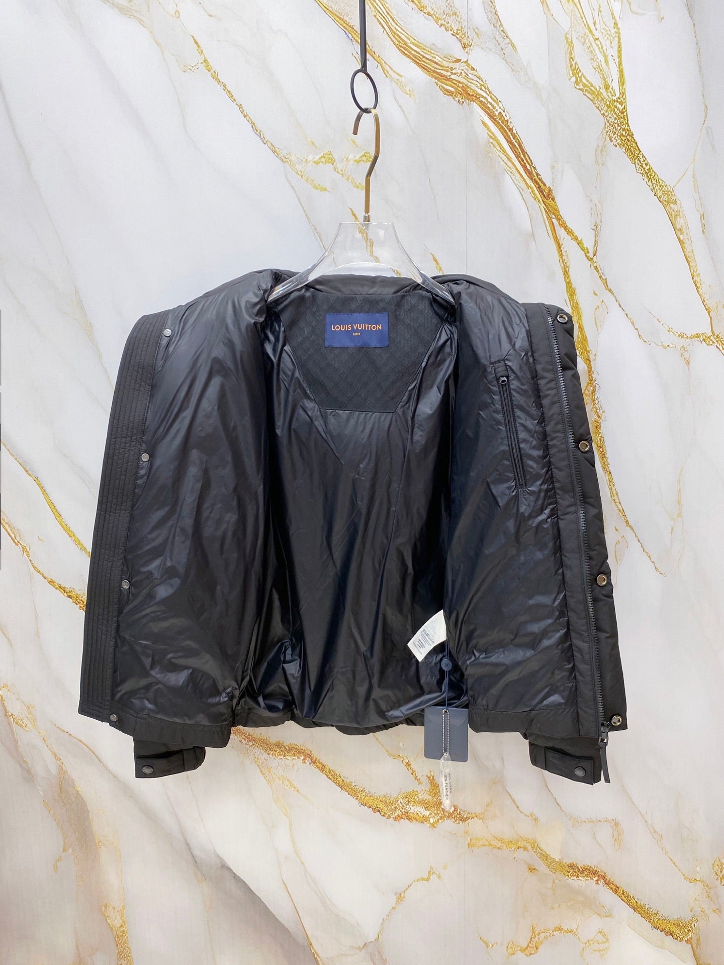 Dark gray puffer jacket interior view with blue neck label and open front