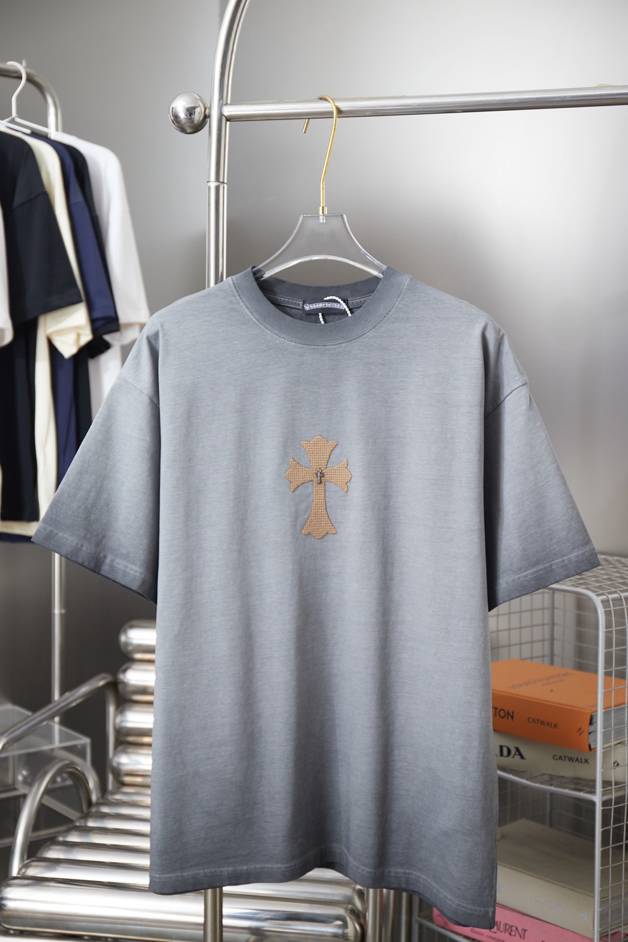 Light blue short-sleeve T-shirt with small cross graphic on the chest