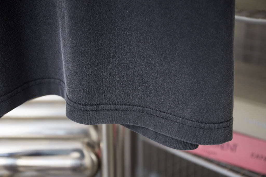 Dark gray T-shirt sleeve hem with double-stitched seam